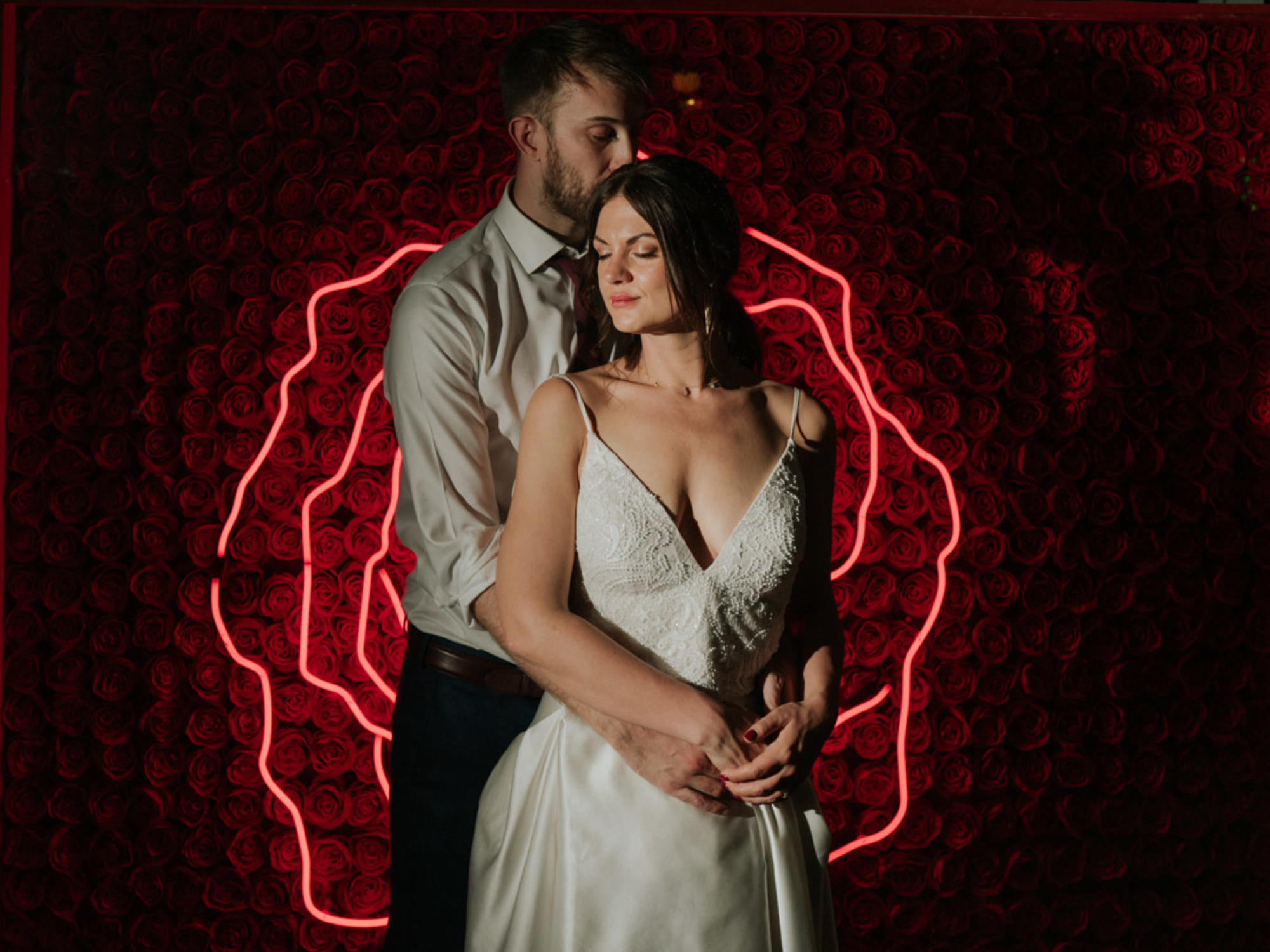 Couple hugging with rose neon sign - wedding photo at One friendly Place, industrial wedding venue in South London