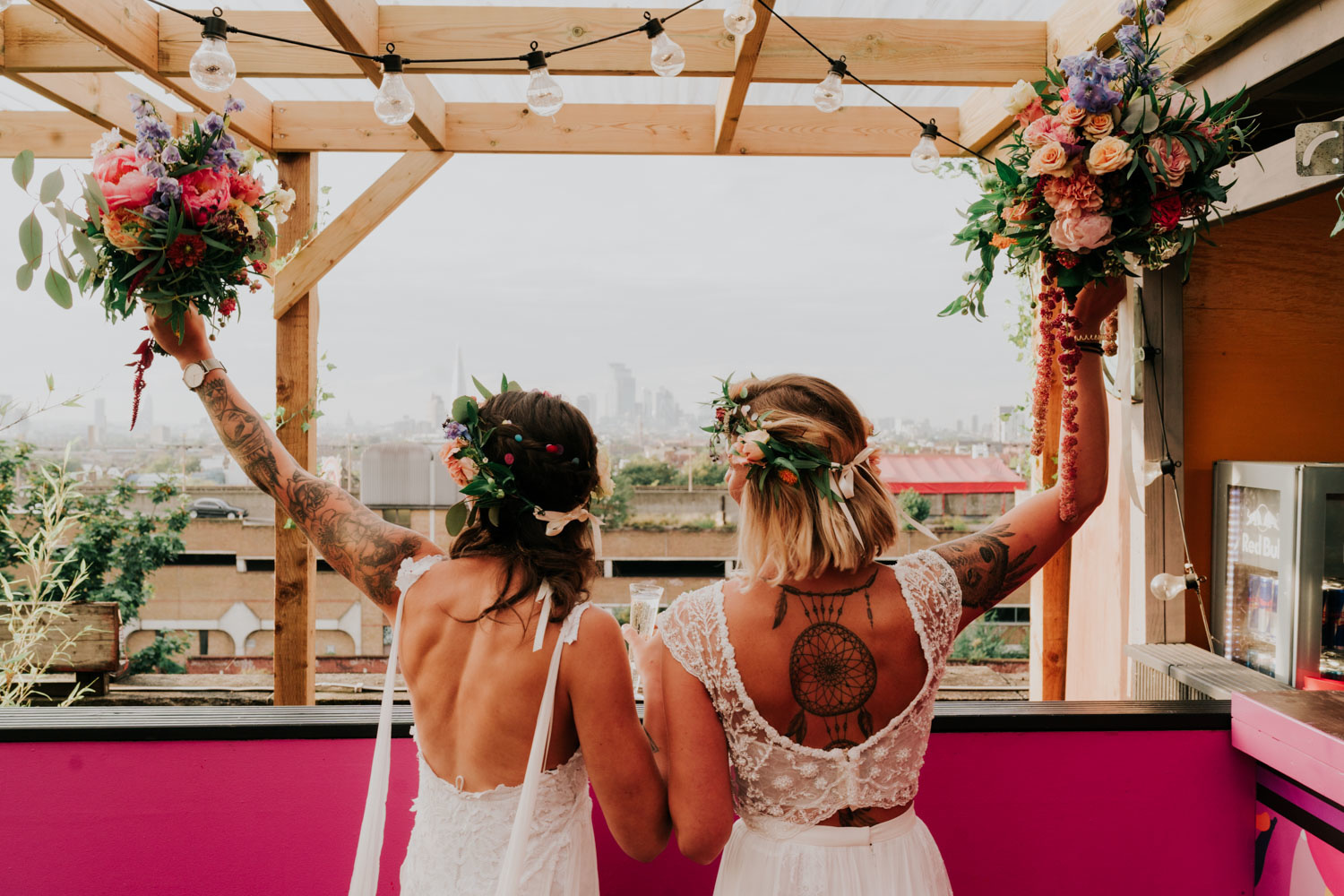 same sex brides holding flowers up