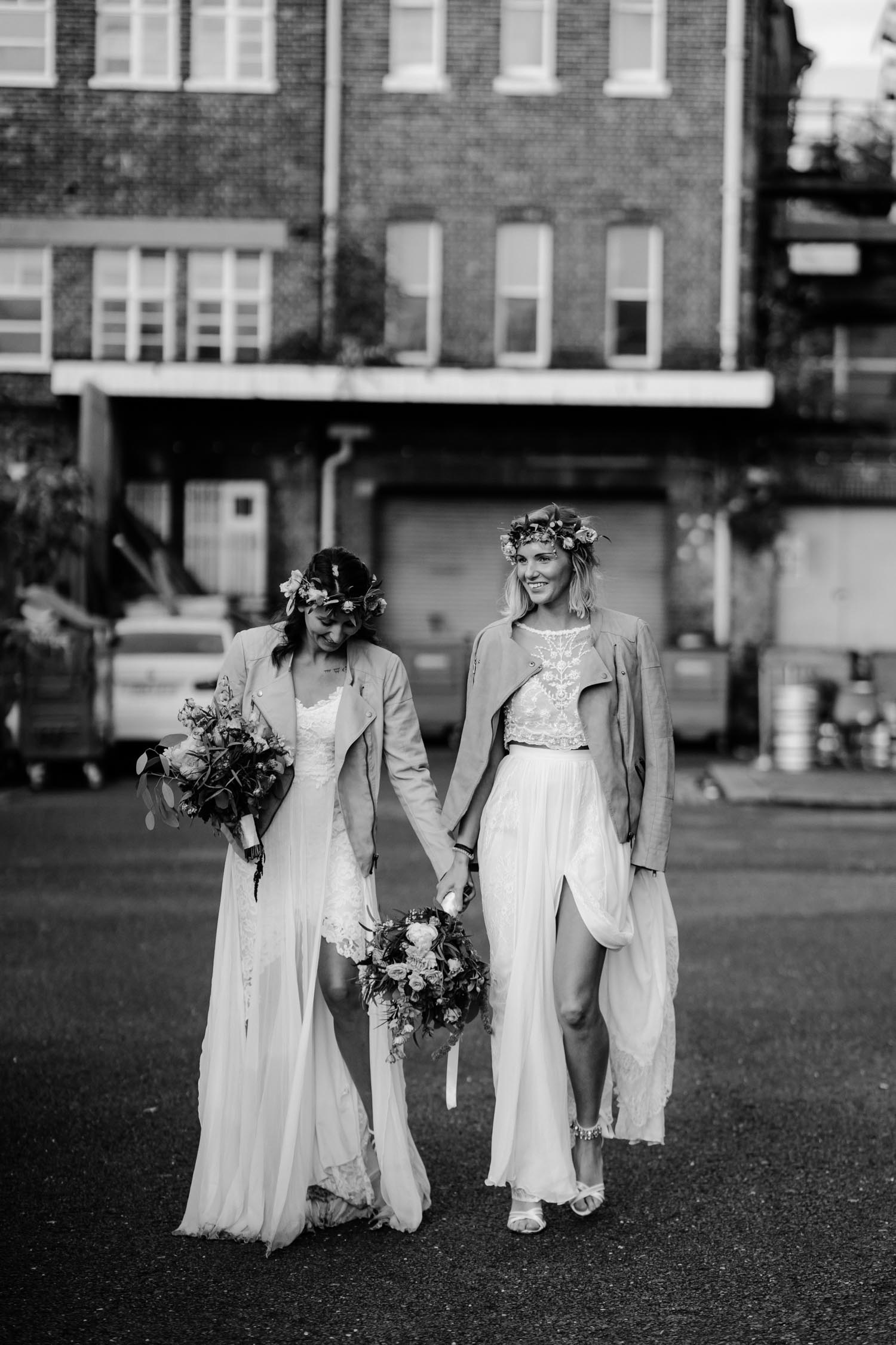 two brides walking and holding hands