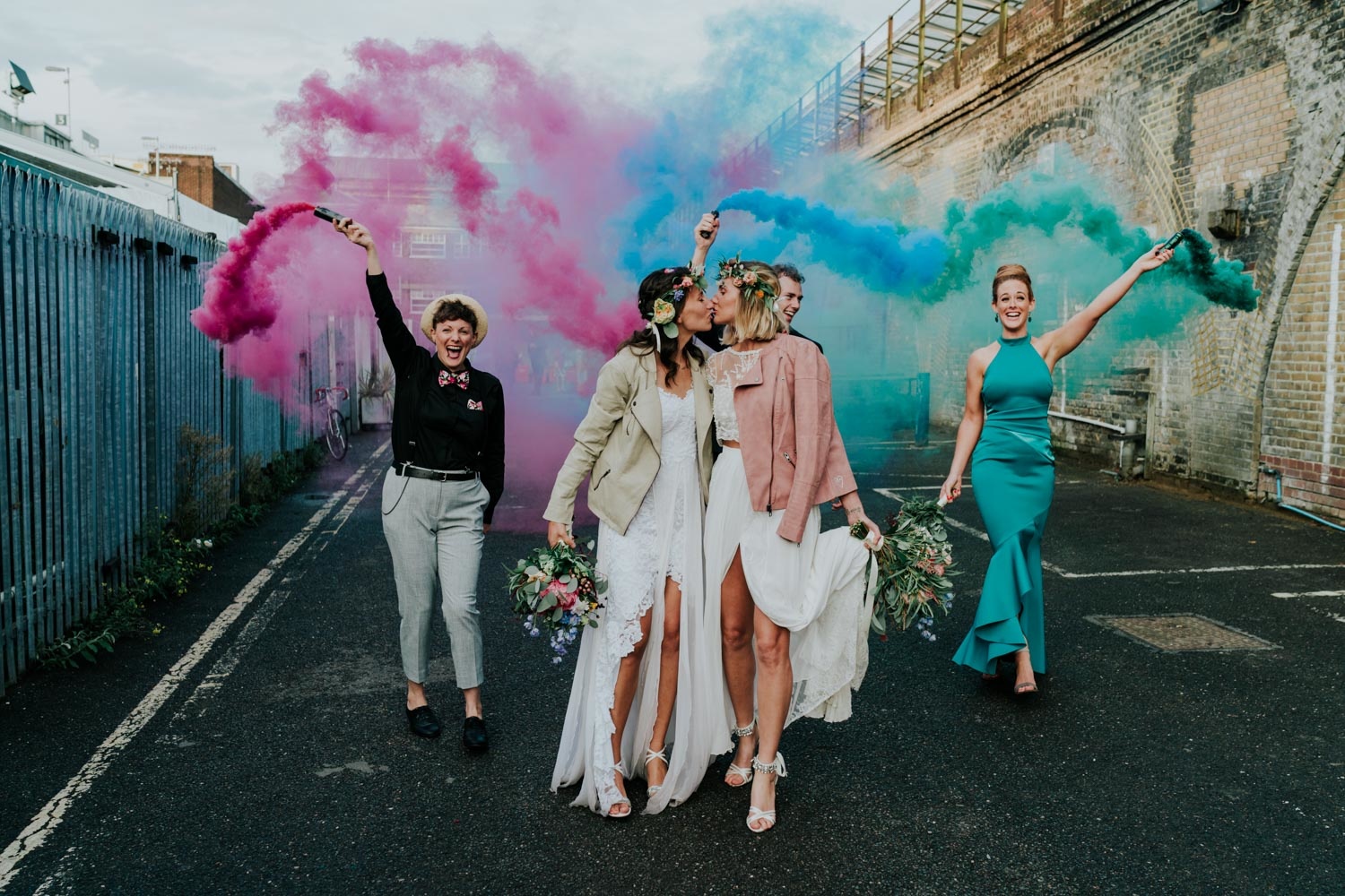 two brides kissing wedding party with smoke bombs