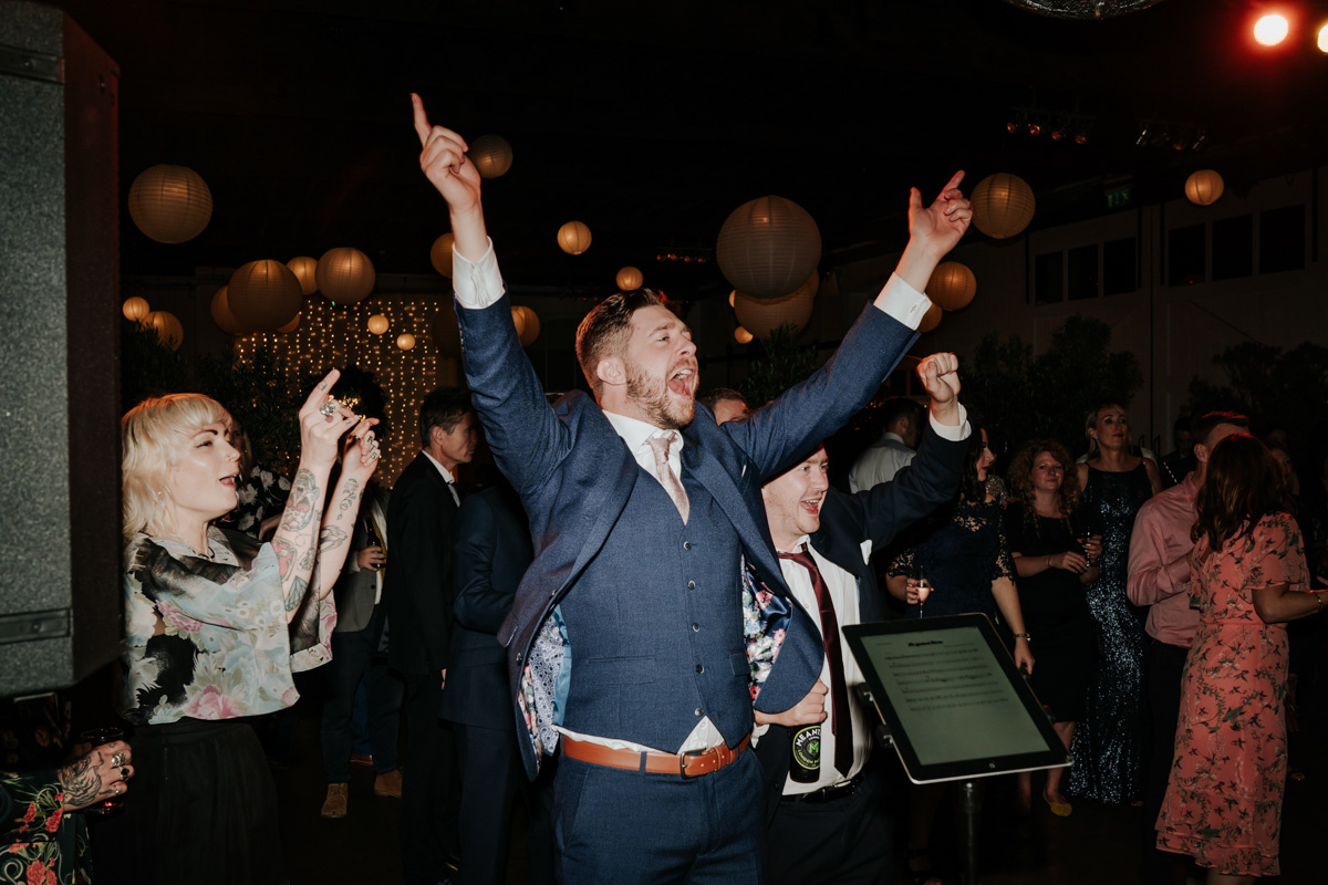 groom dancing with hands up