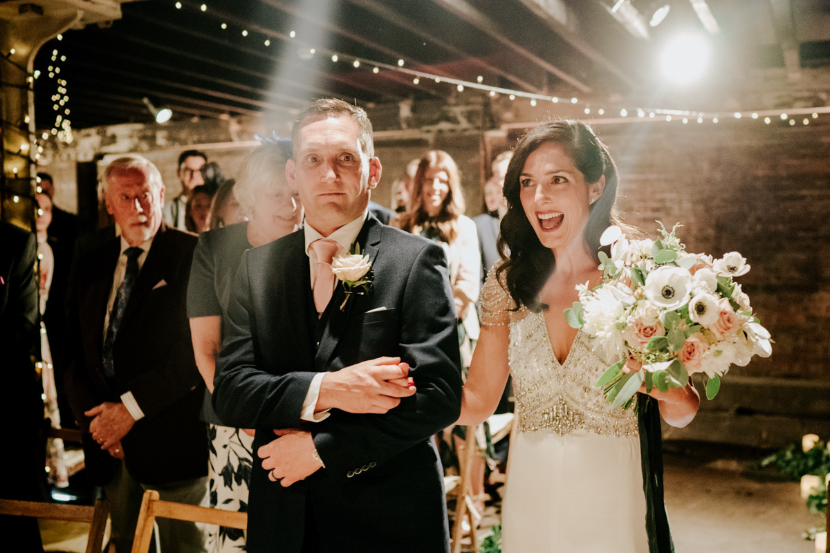 bride with brother walking down the aisle at electricians shop