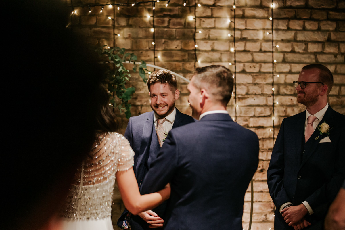 groom smiling seeing his bride for the first time at electricians shop ceremony