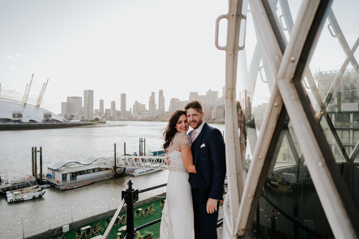 bride and groom hugging at trinity buoy wharf lighthouse balcony