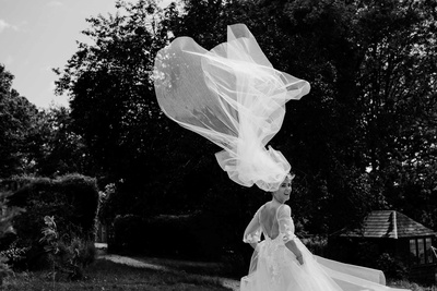 documentary london wedding photographer's image of a bride with veil blown away by wind in black and white.