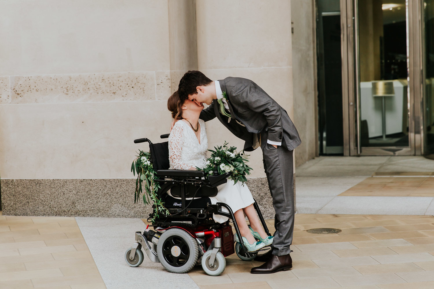 groom kissing bride in a wheelchair