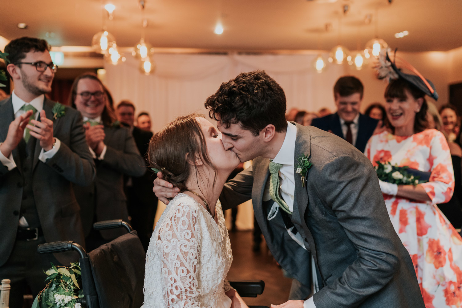 bride in a wheelchair and groom first kiss