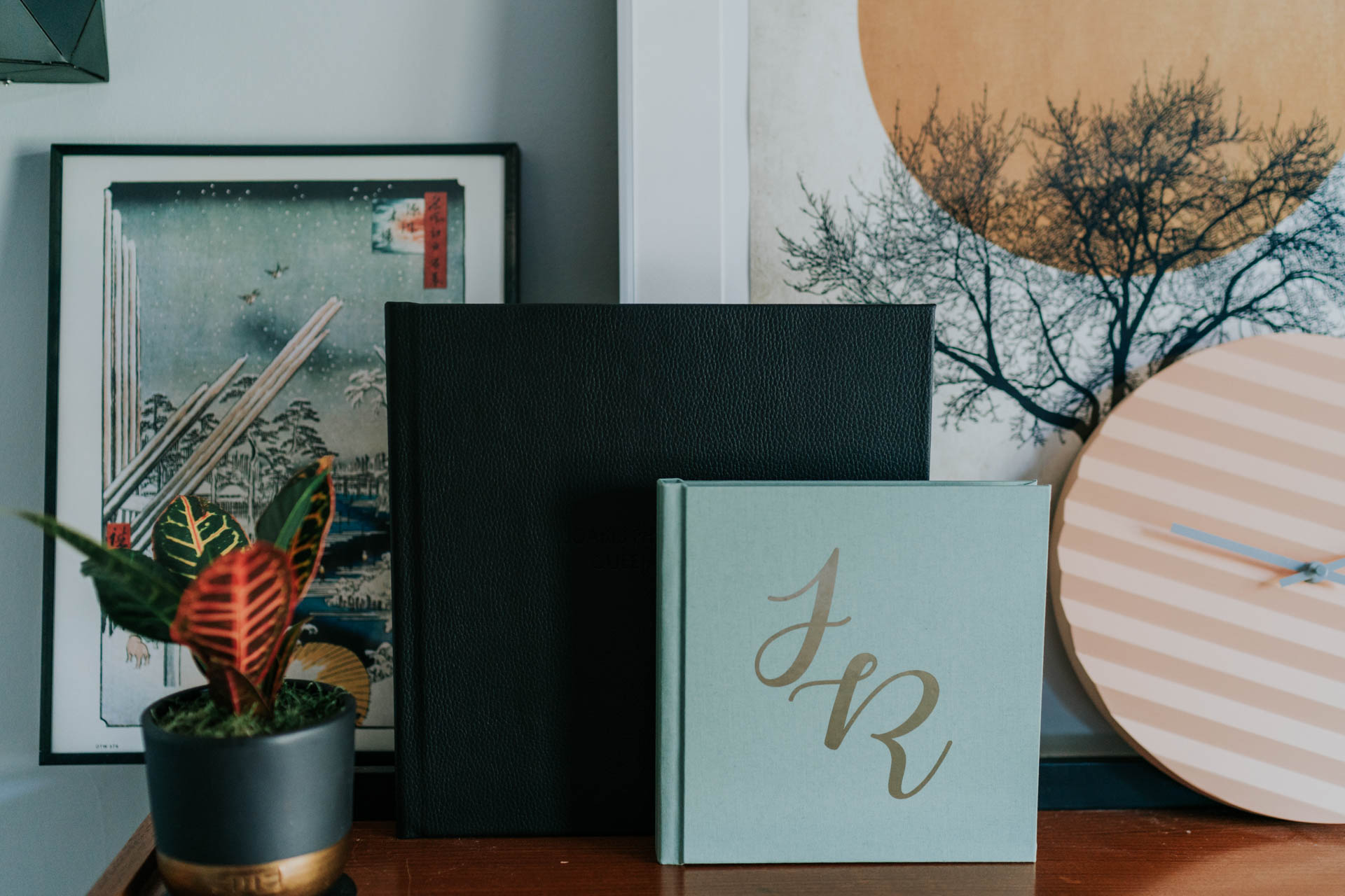 wedding albums in black and mint on a bookshelf