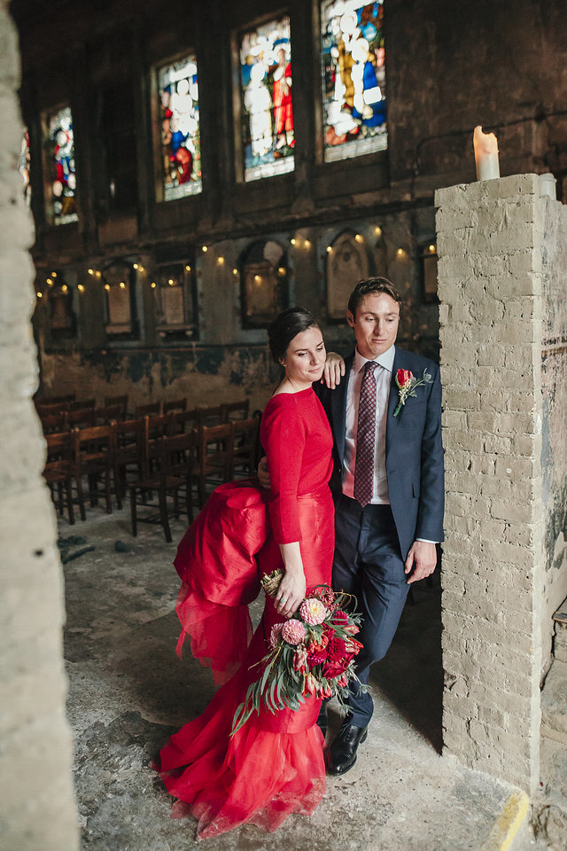 artistic portrait of a bride in red dress and groom at the asylum chapel in peckham