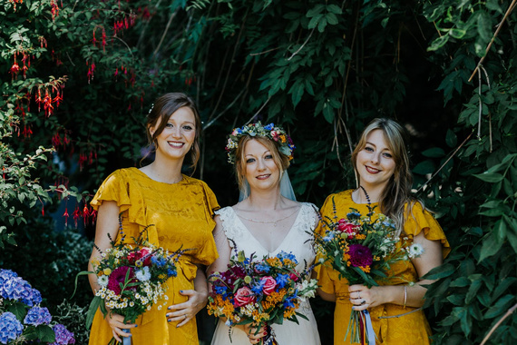 chilley barn wedding with colourful bridesmaids in yellow, and boho bride with flower crown. east sussex wedding photographer with hastings museum ceremony