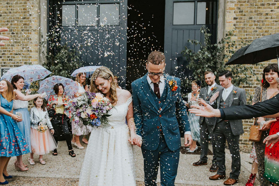 confetti over bride and groom leaving Trinity Buoy Wharf ceremony at Chainstore. Photo by London wedding photographer Joasis.