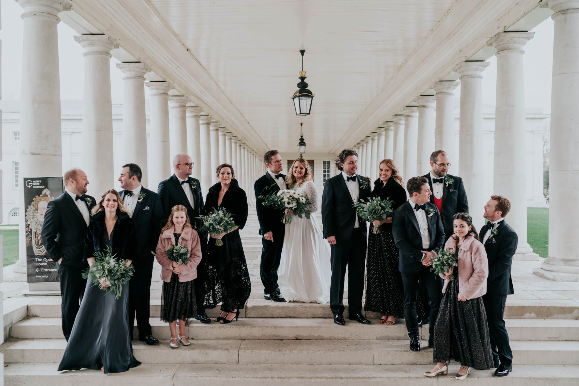Wedding party photo on steps of a collonade