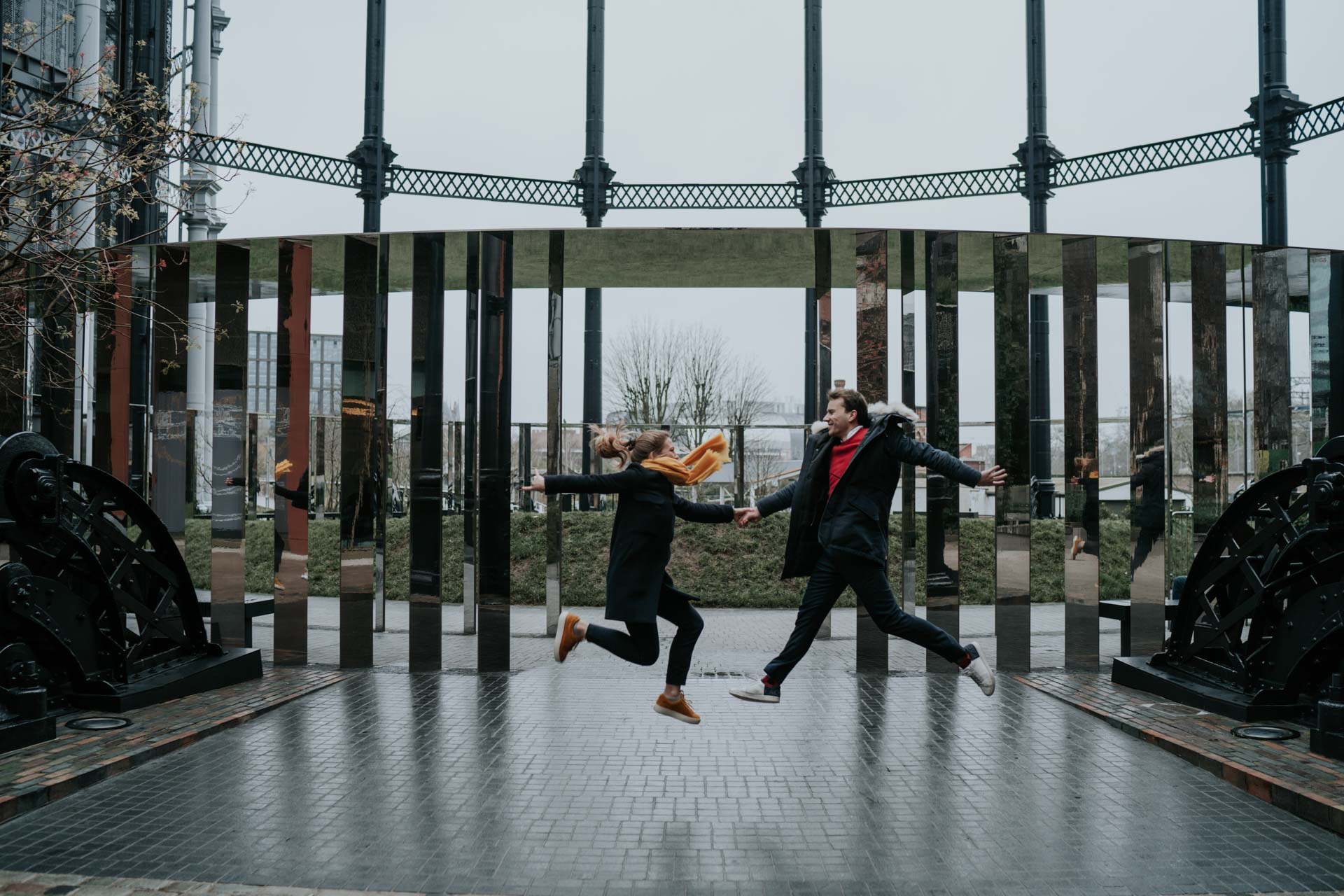 fun engagement photography with couple jumping in coal's yard