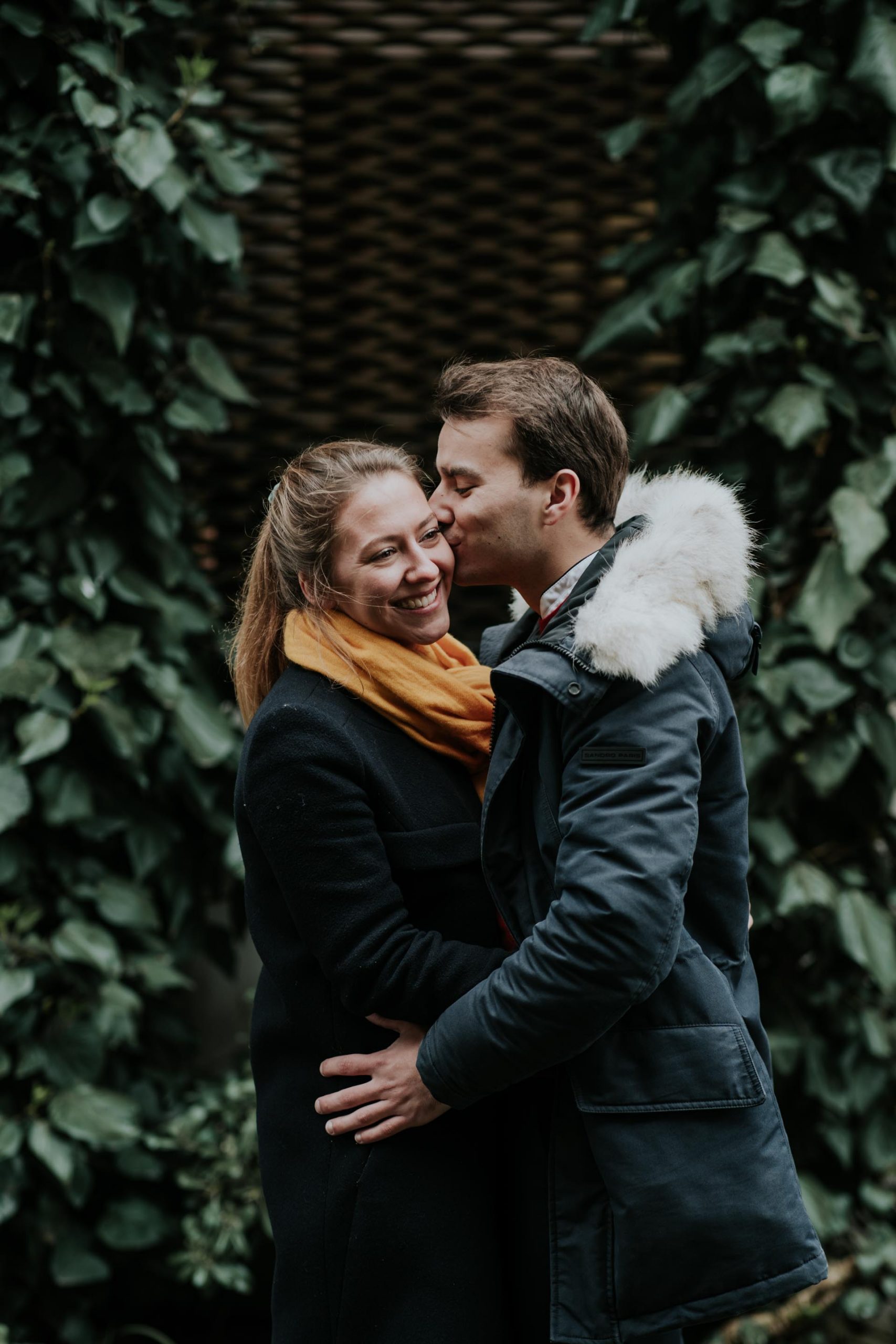 couple kissing in winter clothes with yellow scarf