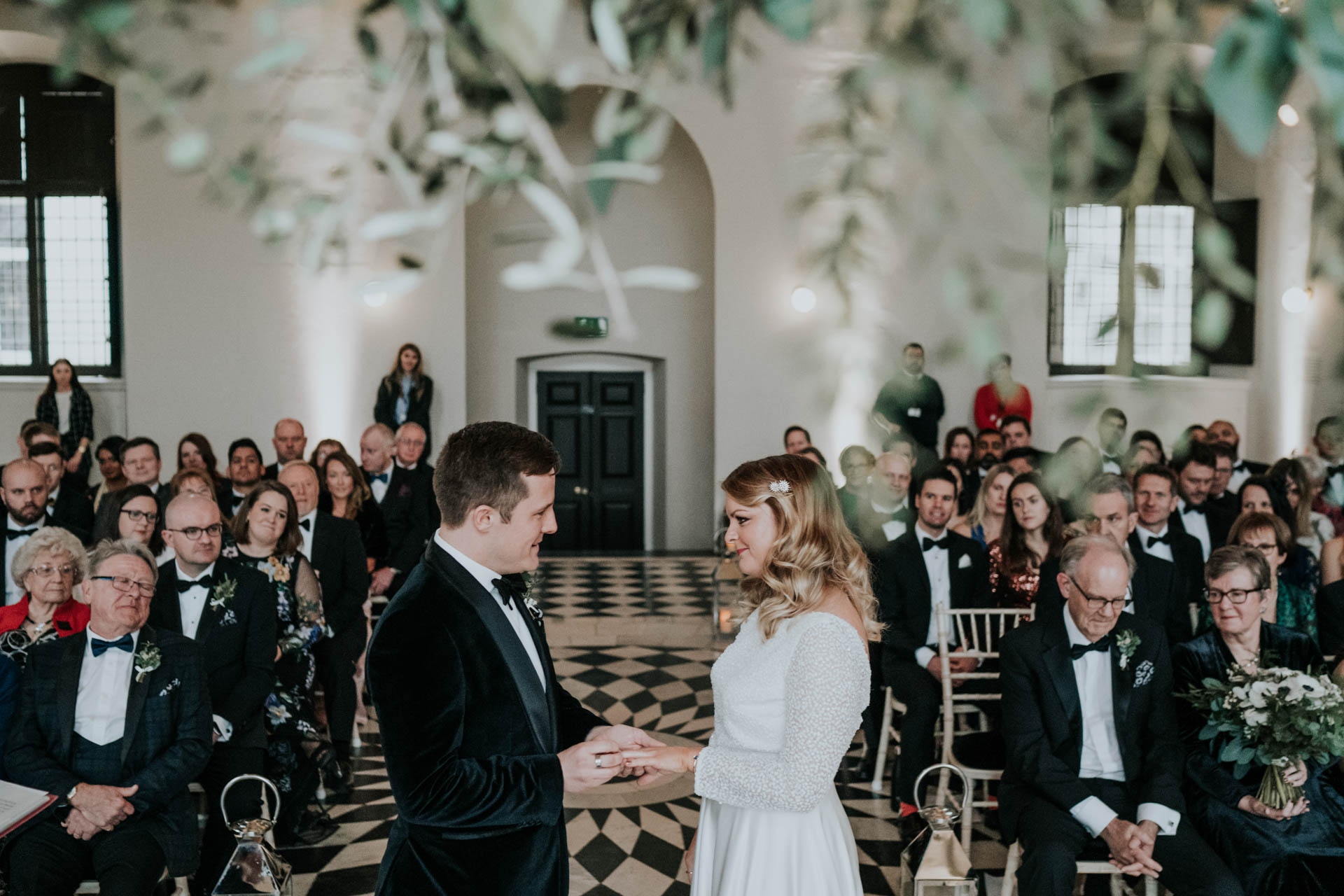 groom putting a ring on brides finger