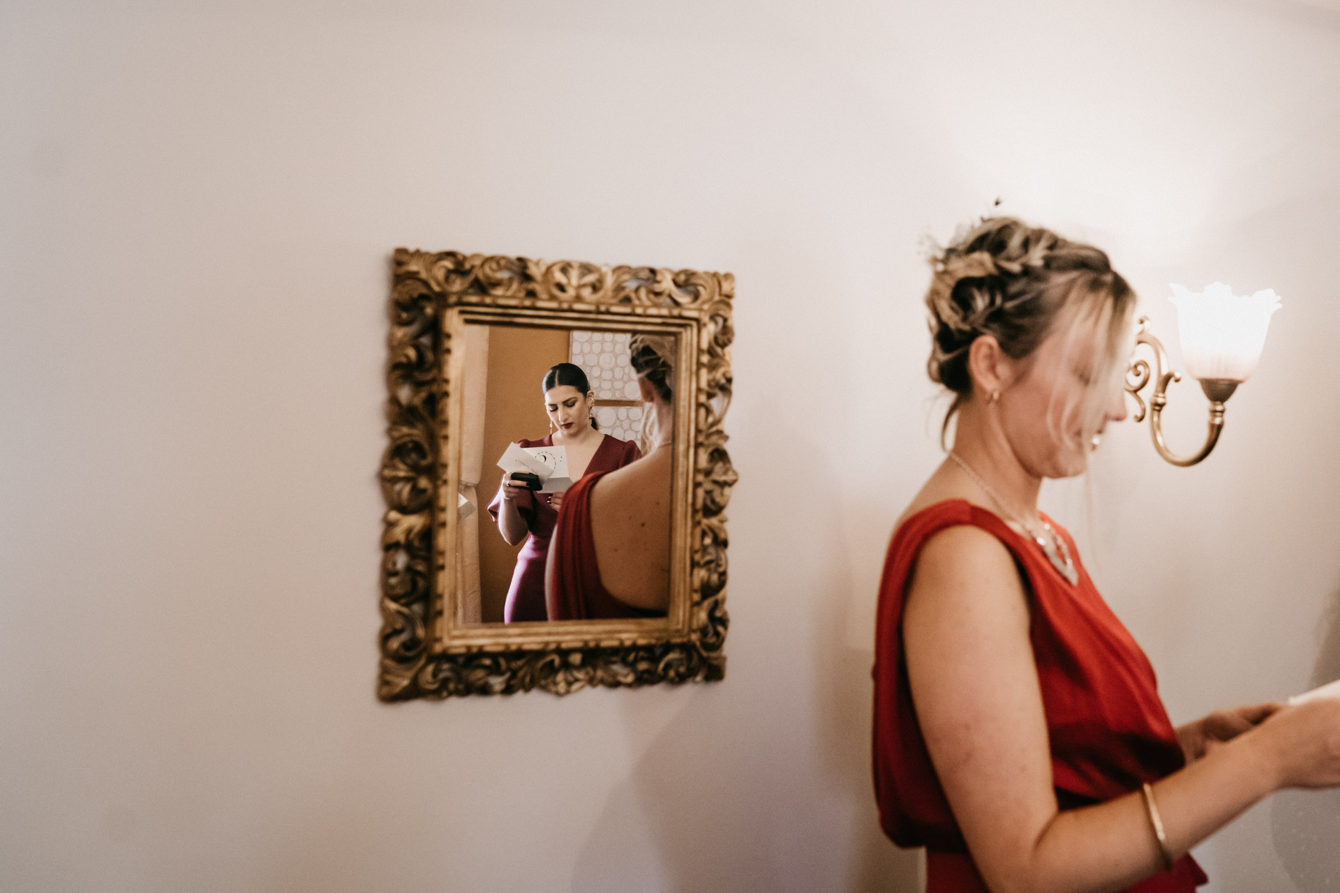 bridesmaid reading a letter reflection in a mirror