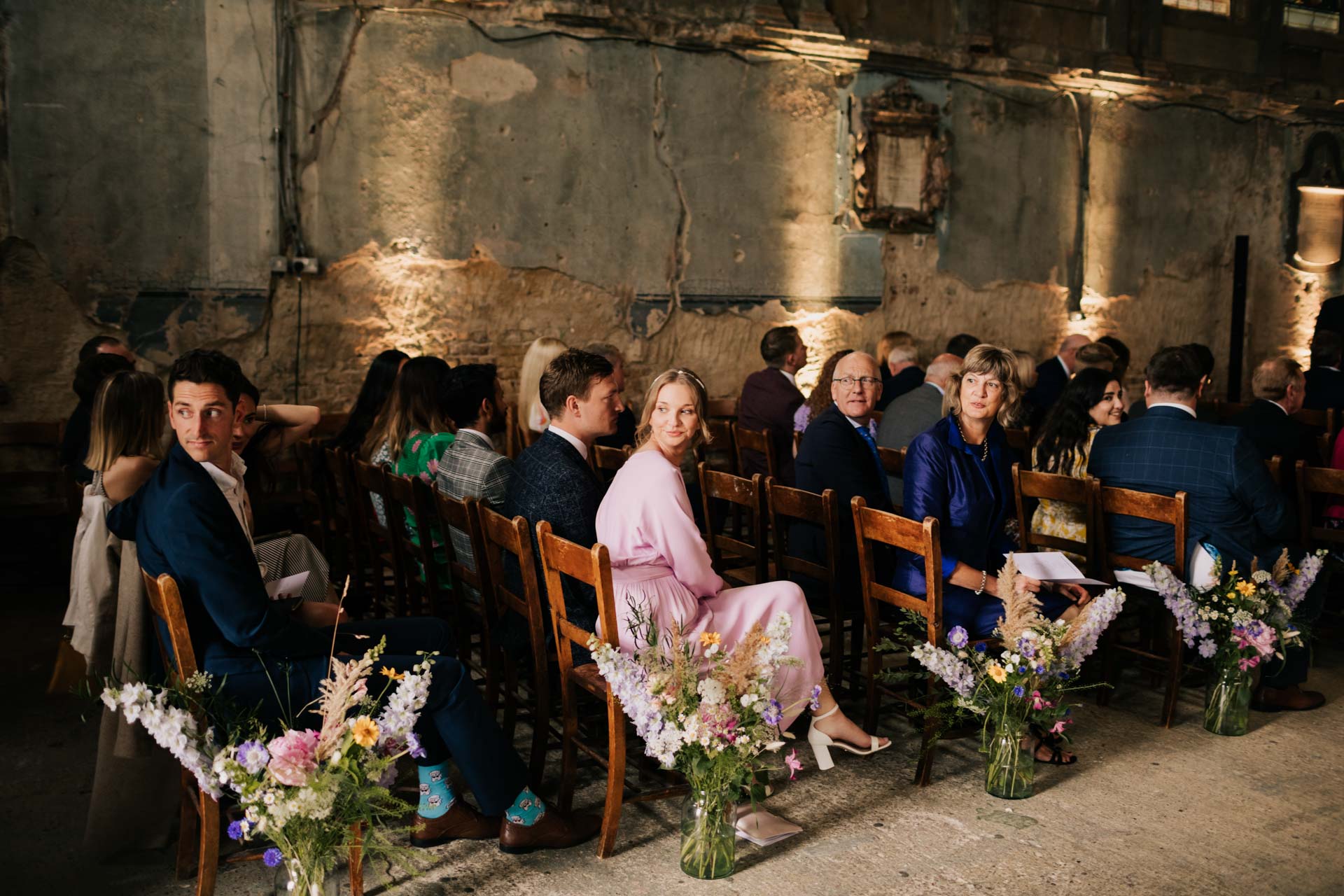 guest in pink dress looking behind at asylum chapel