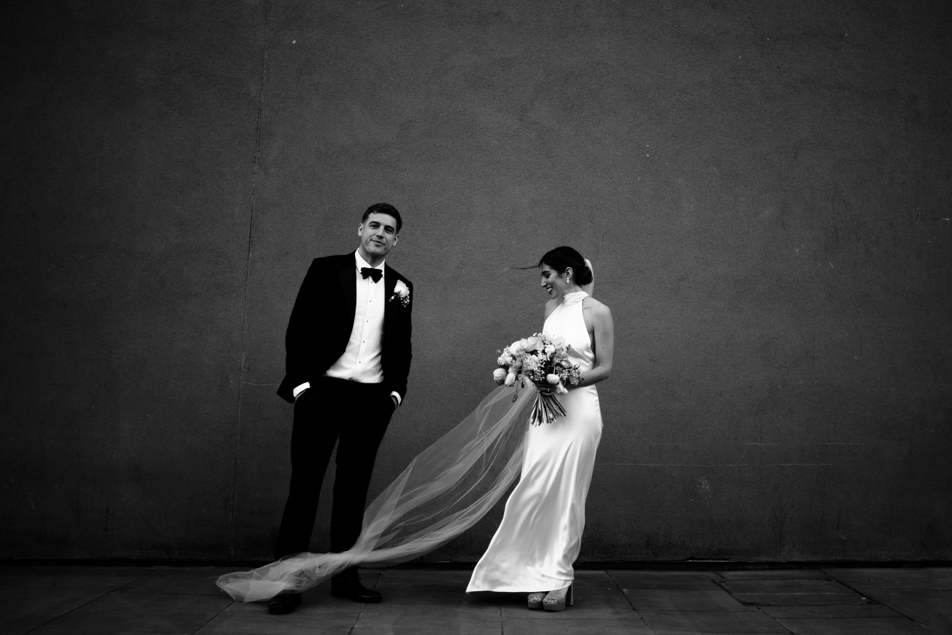bride and groom in black and white outside andaz hotel
