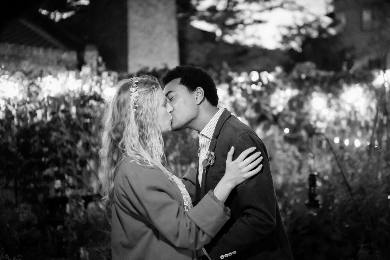 bride and groom kissing at night lit up by festoon lights at Brunel Museum after their wedding