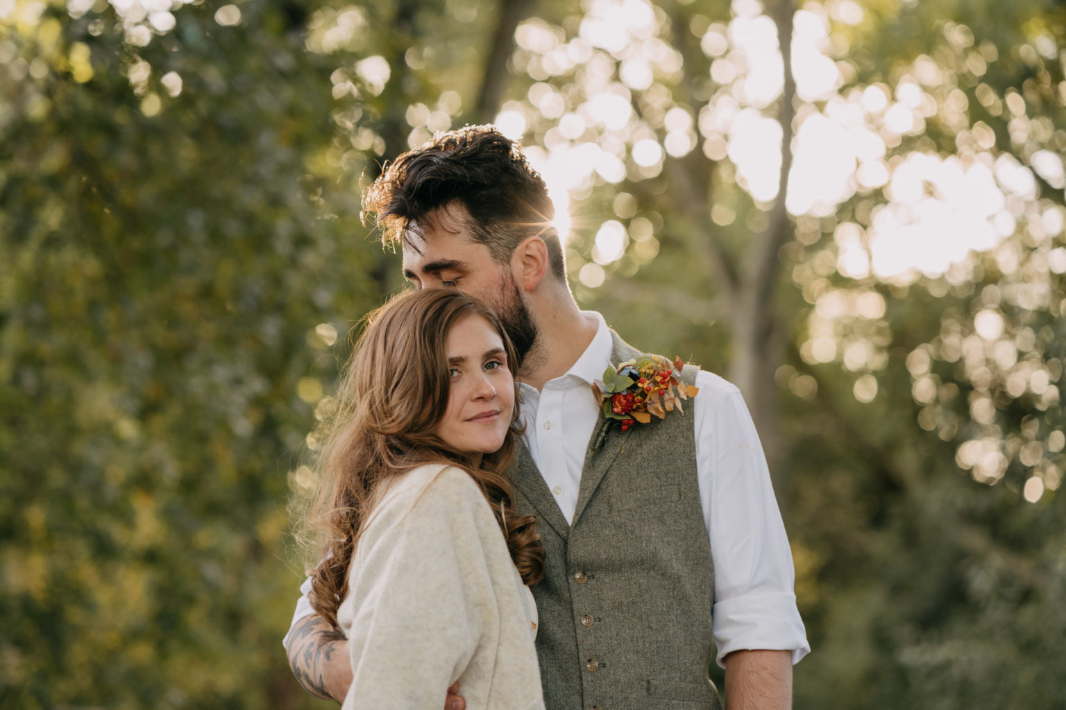 groom kissing bride's head at Beckenham Place grounds