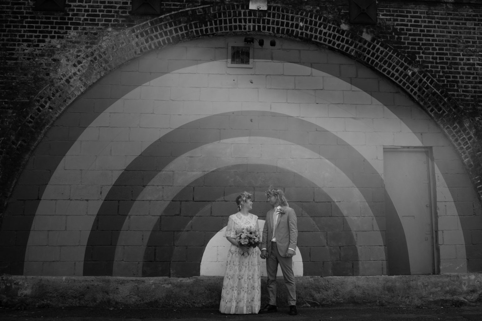 bride and groom outside 100 barrington road rainbow in black and white