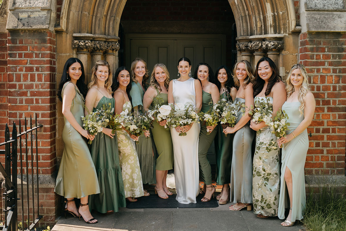 bride and bridesmaids in mixed green dresses posing for london wedding photographer