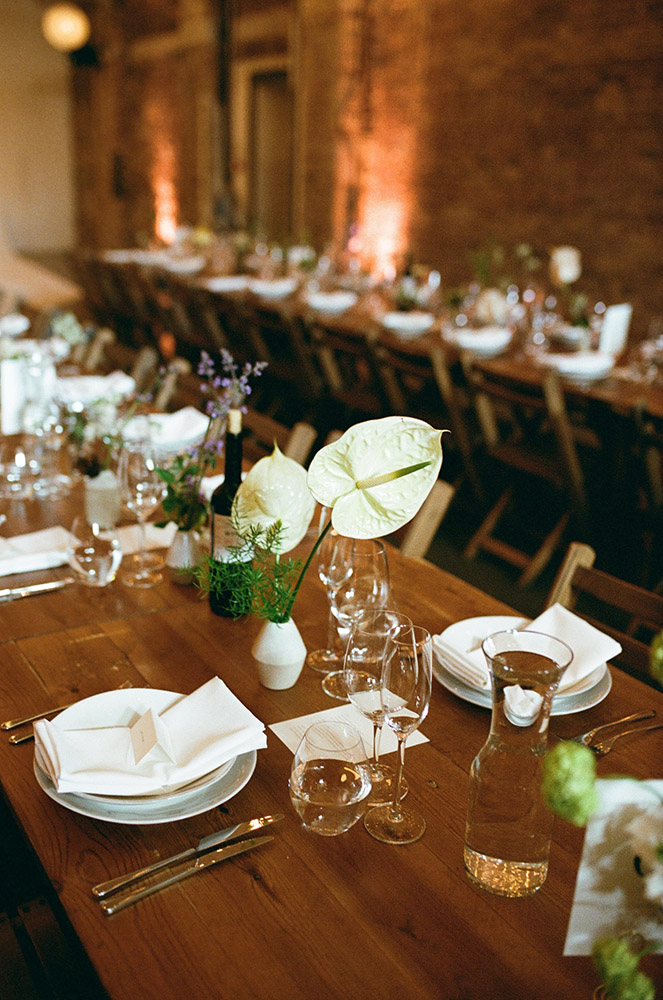white flower and wooden tables at shoreditch studios wedding reception