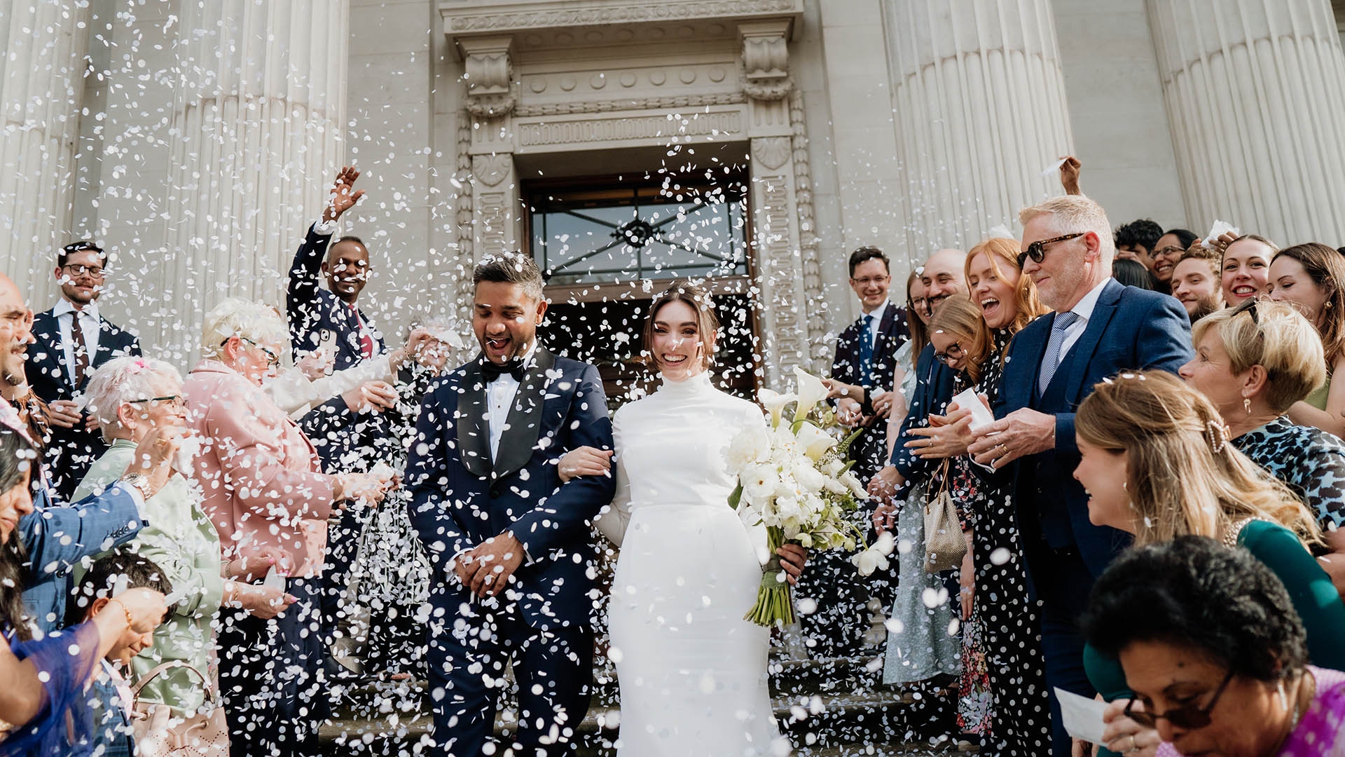bride and groom in confetti at the old marylebone town hall in london