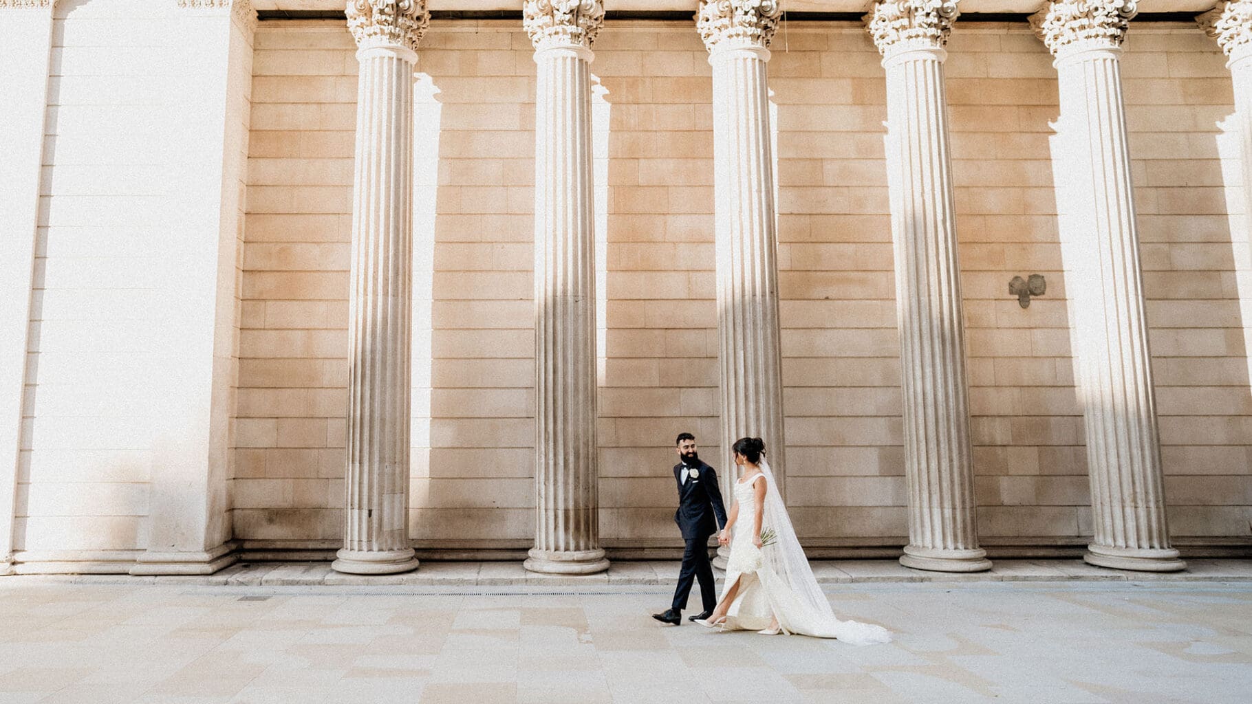 bride and groom walking in city of london captured by film wedding photographer