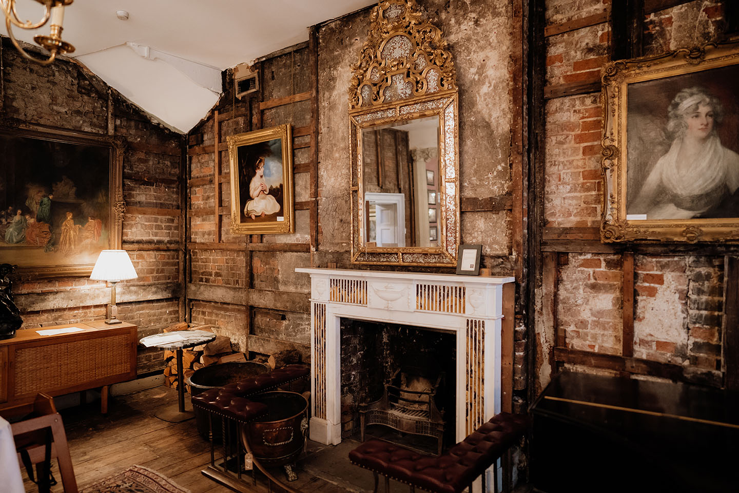 exposed brick and antique painting near a fireplace in brunswick house wedding venue