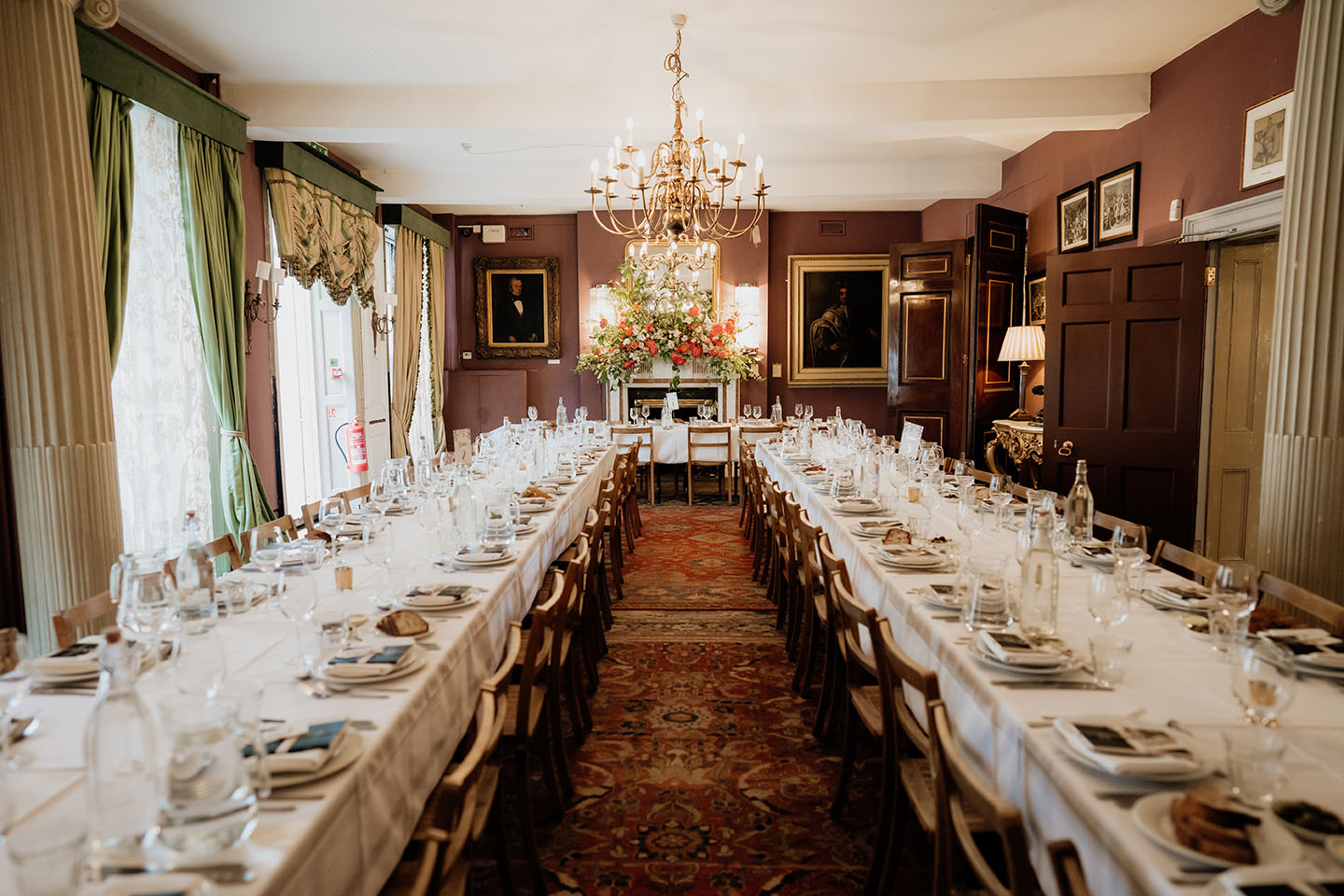 brunswick house wedding photography - a reception room set up with long tables and colourful red and white florals above the headtable
