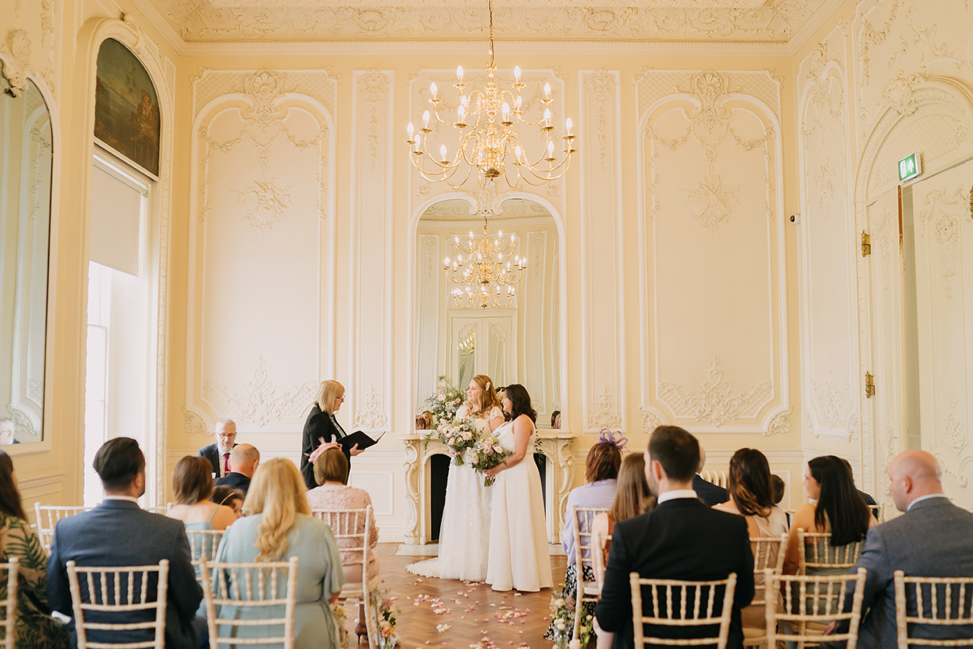 two brides during their ceremony in the music room at the 10 -11 carlton house terrace