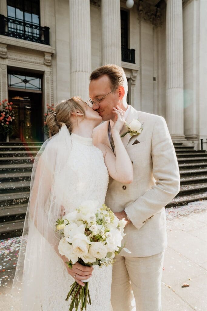bride kissing groom at iconic old marylebone town hall steps for their elopement photography