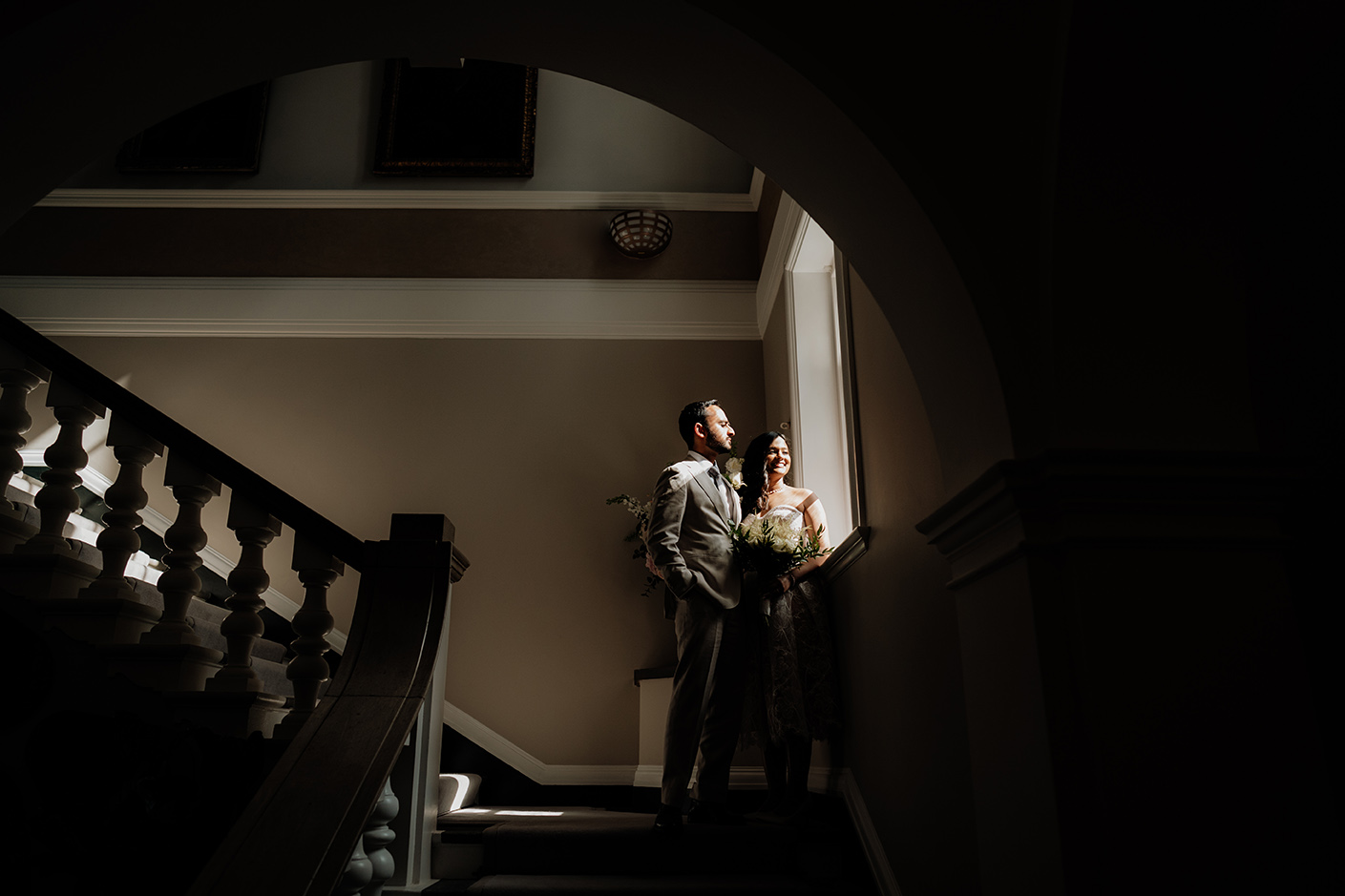 cinematic portrait of bride and groom looking at the window at the chelsea old town hall 