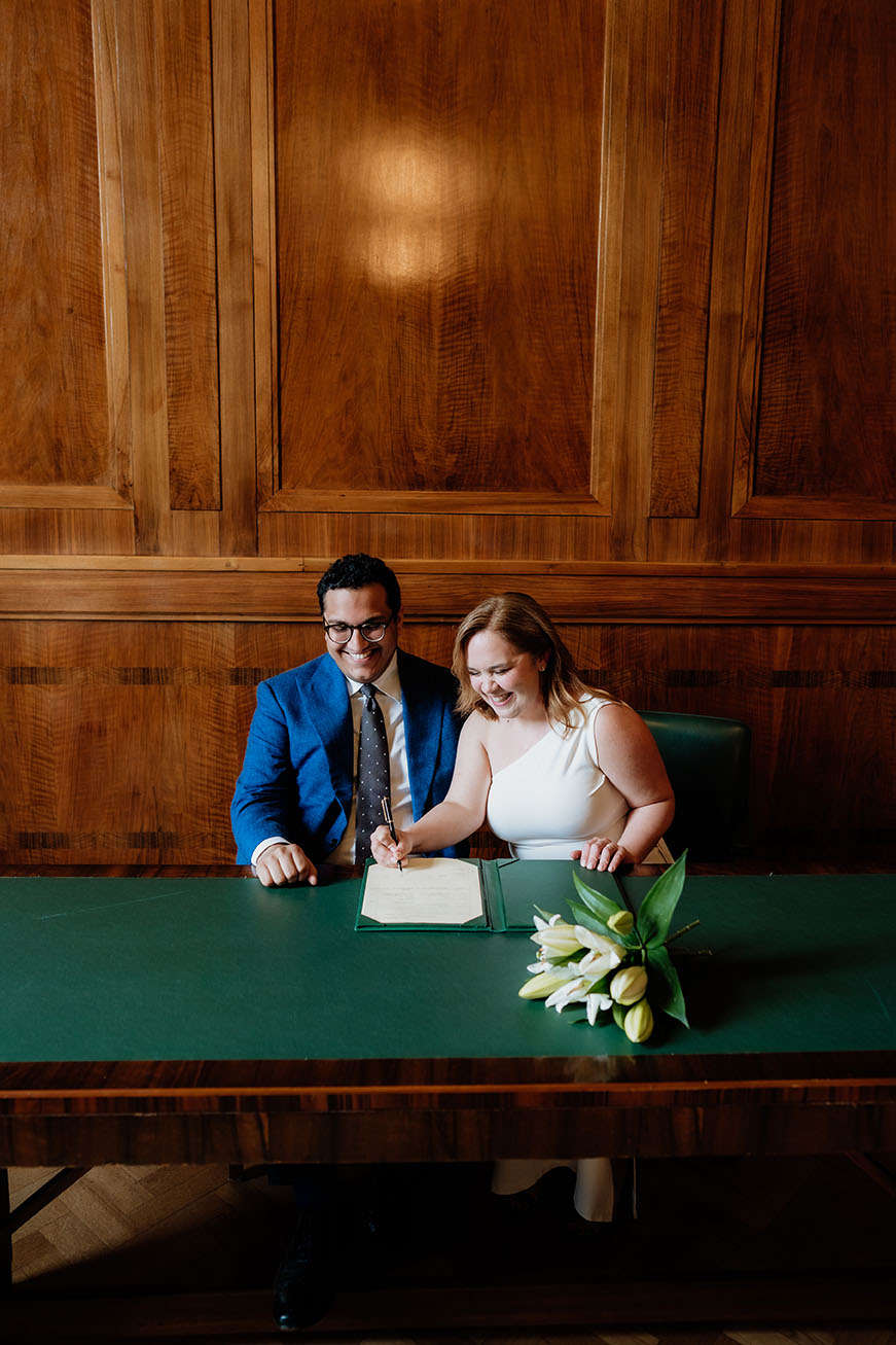 bride signing the register at the committee room at the hackney town hall 