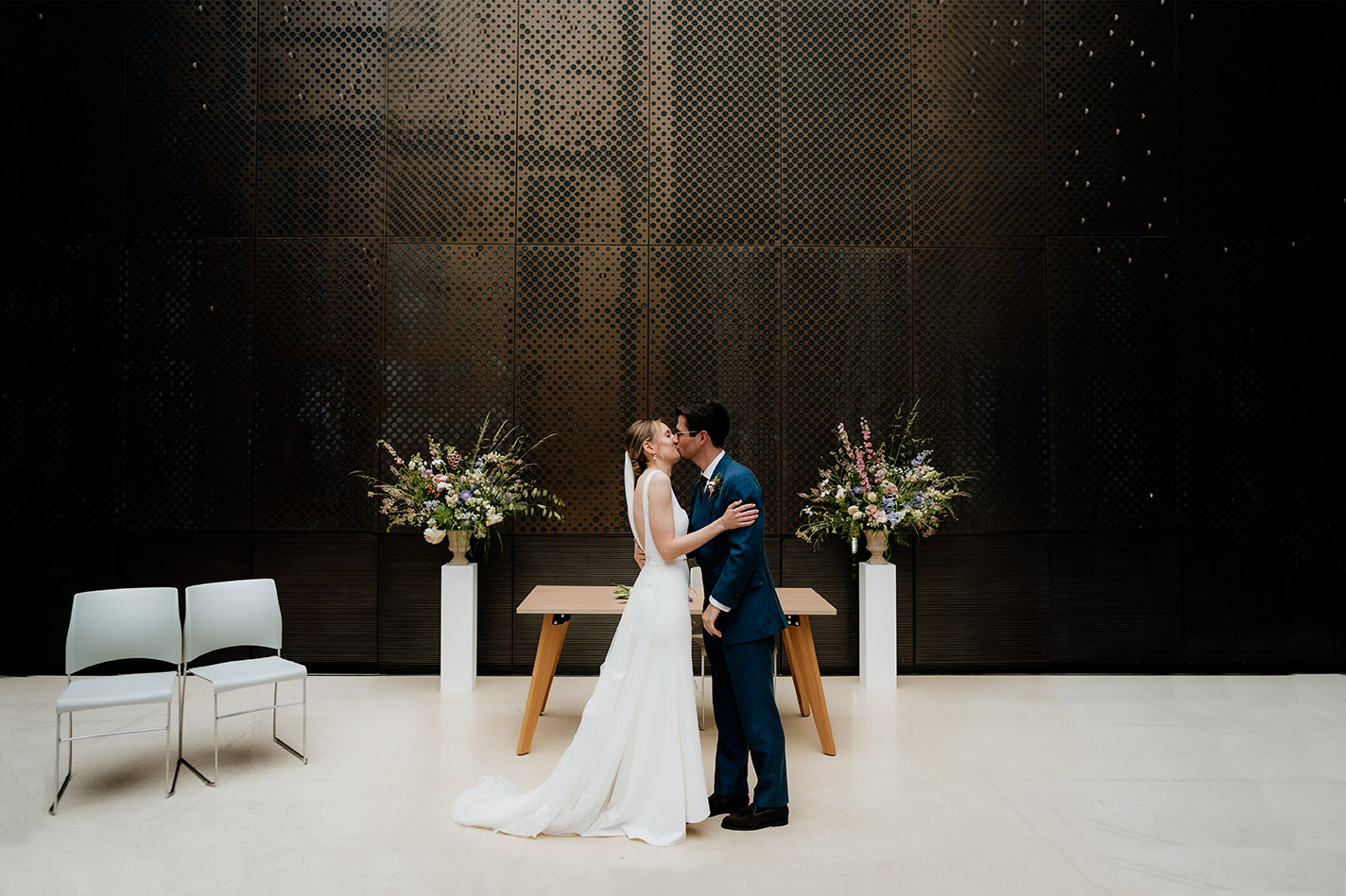 bride and groom first kiss at the north atrium in the hackney town hall wedding