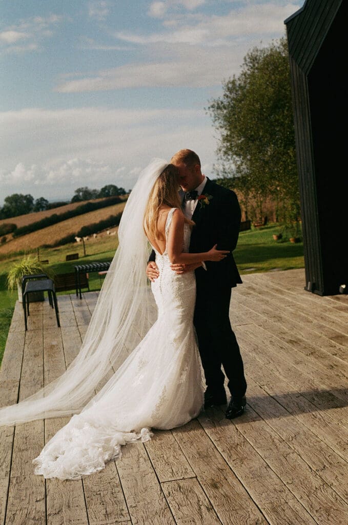 romantic photo of bride and groom hugging outside botley hill barn wedding venue