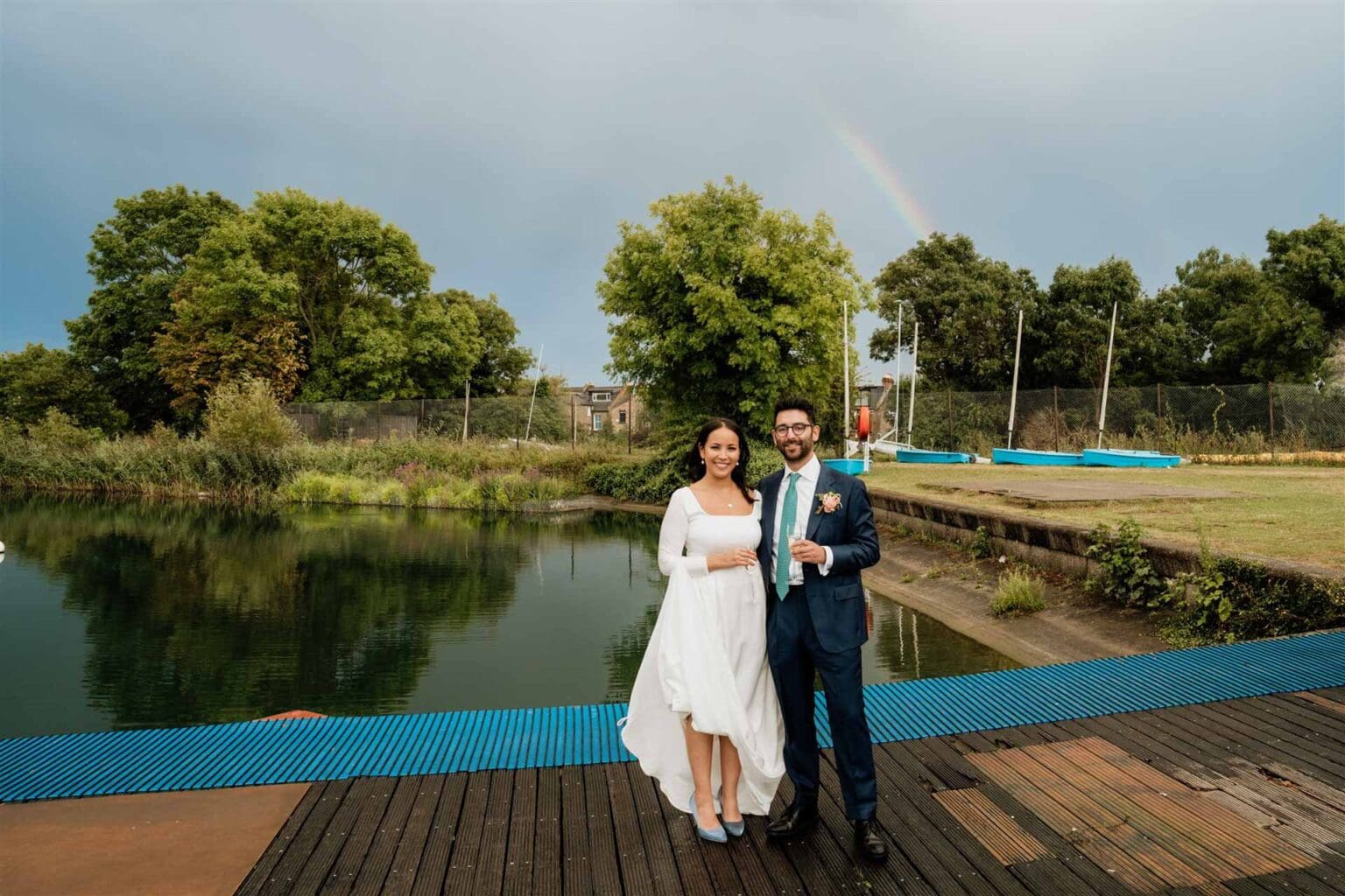 post wedding rain rainbow showed up with dramatic sky for a relaxed couple portrait in london wetlands