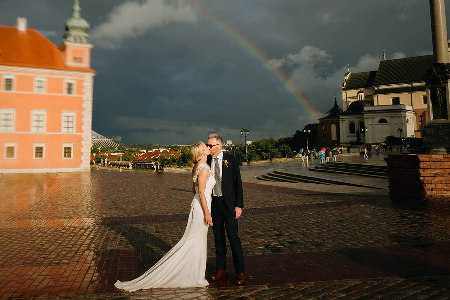 big rainbow and strong dramatic light for this wedding portrait on a rainy wedding day