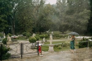 strong rain shower on a wedding day with guests running under umbrellas