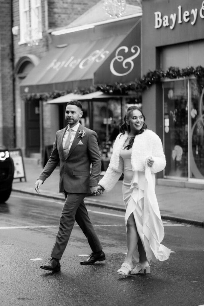 bride and groom walking on London streets and smiling despite cold wedding weather