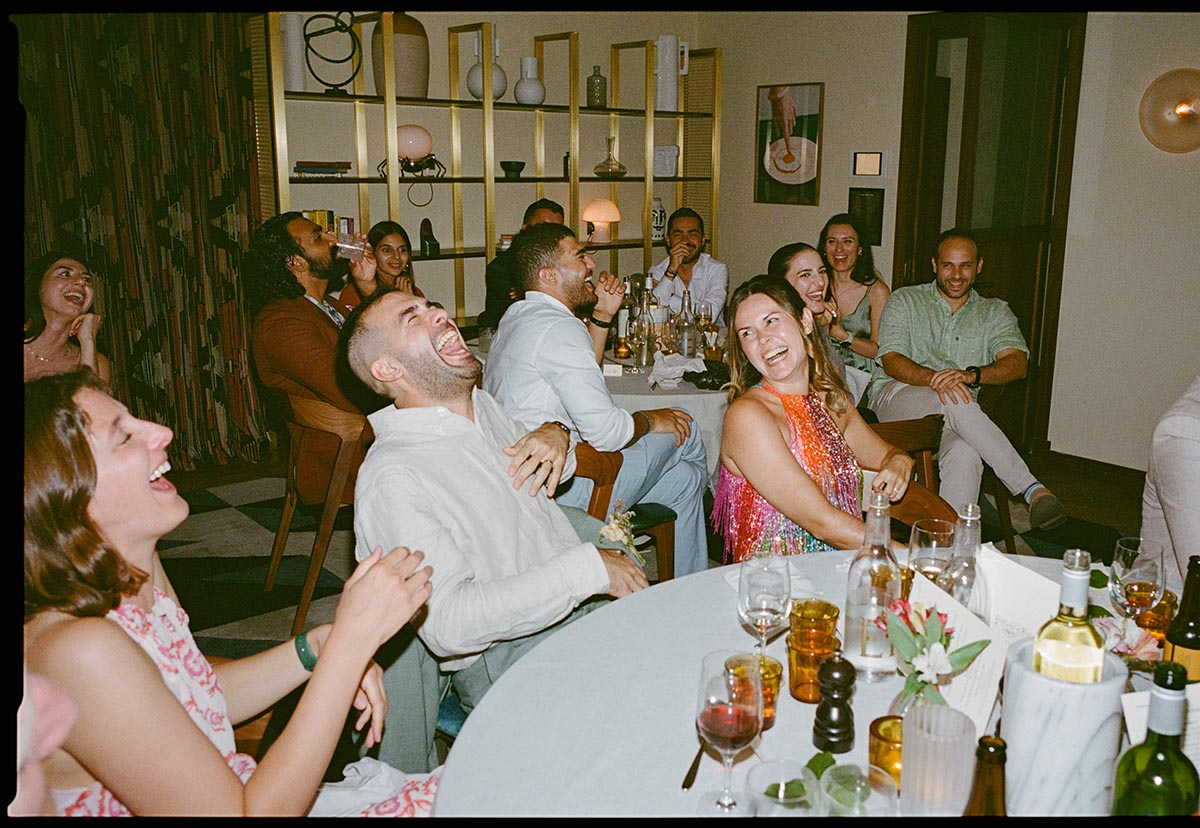 guests laughing during speeches captured on 35mm film candidly