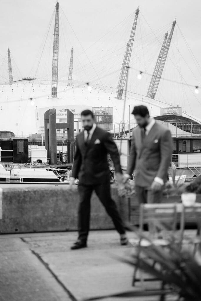 cinematic photo of two grooms at trinity riverside london wedding