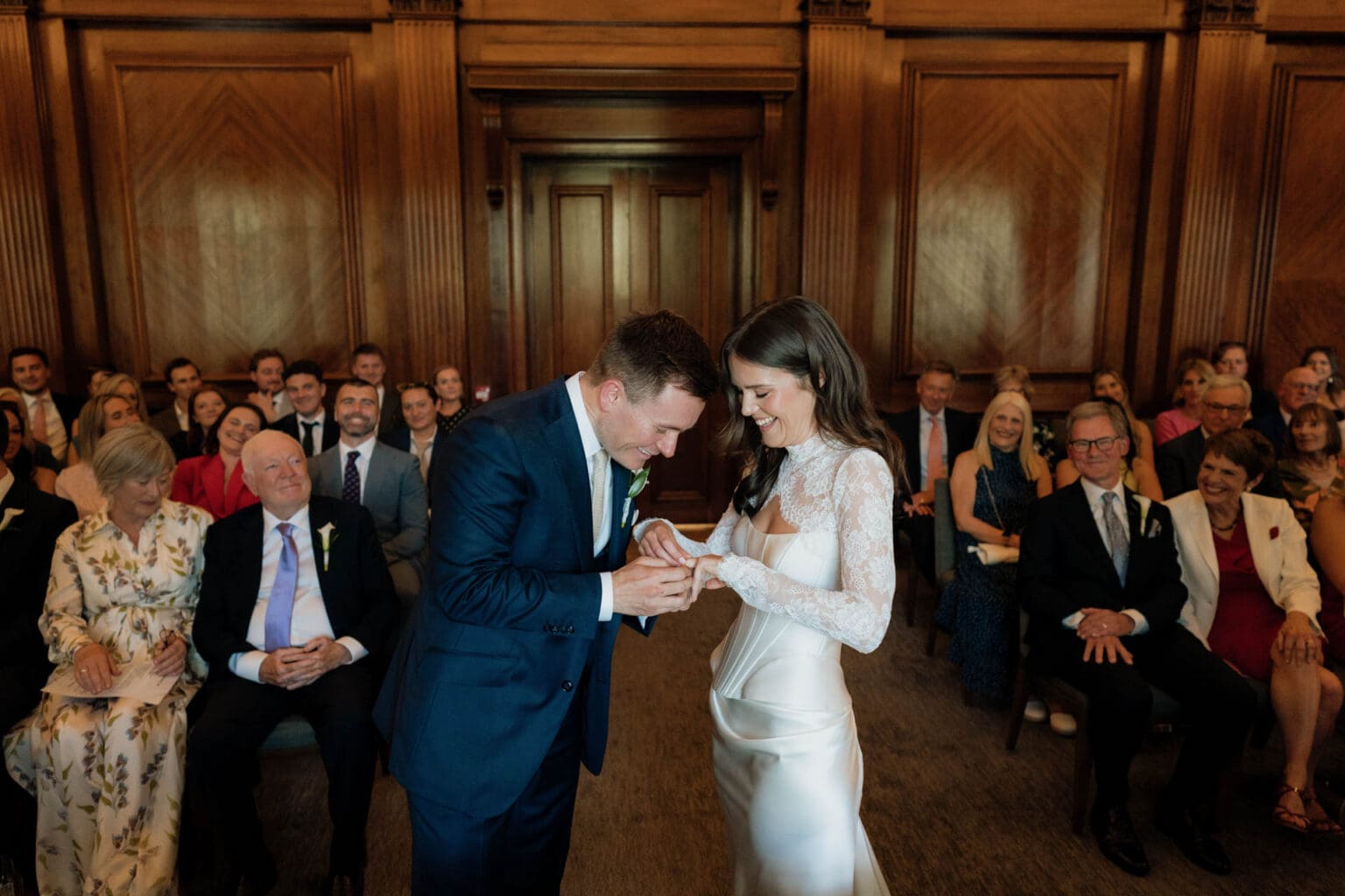 fun photo of bride and groom exchanging rings at marylebone town hall
