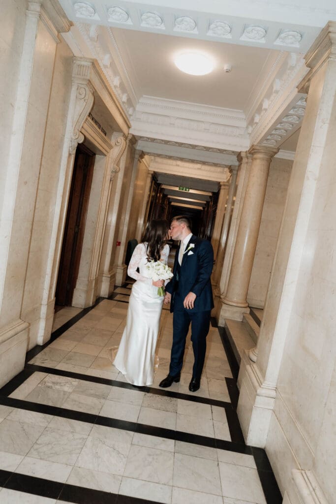 candid editorial wedding photo in the corridor of old marylebone town hall with direct flash