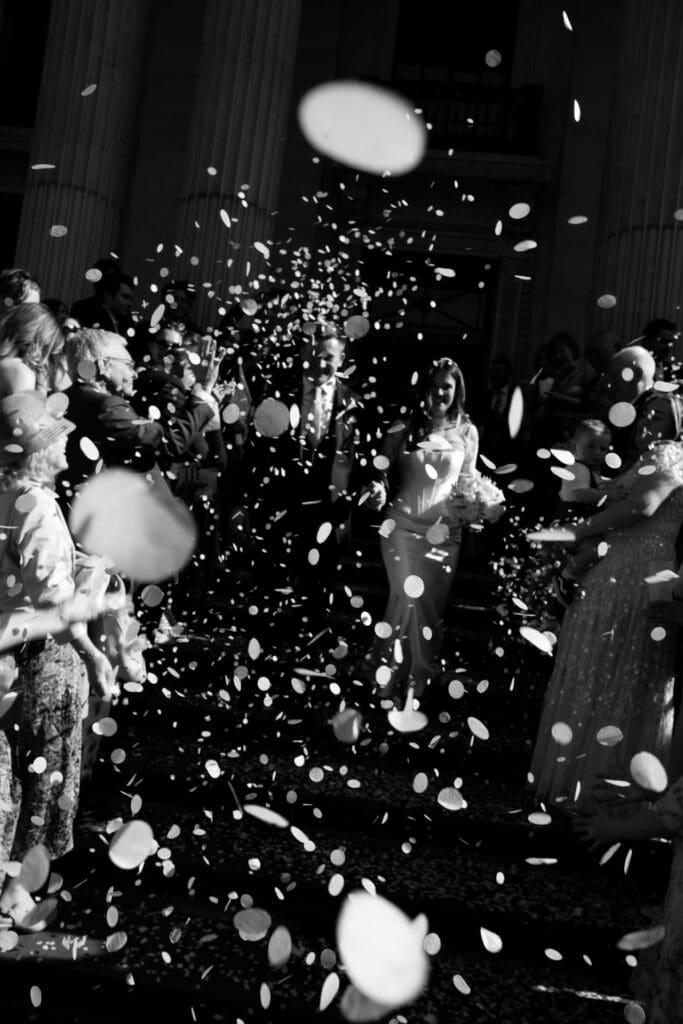 high contrast black and white confetti photography on steps of marylebone town hall , biodegradable paper confetti